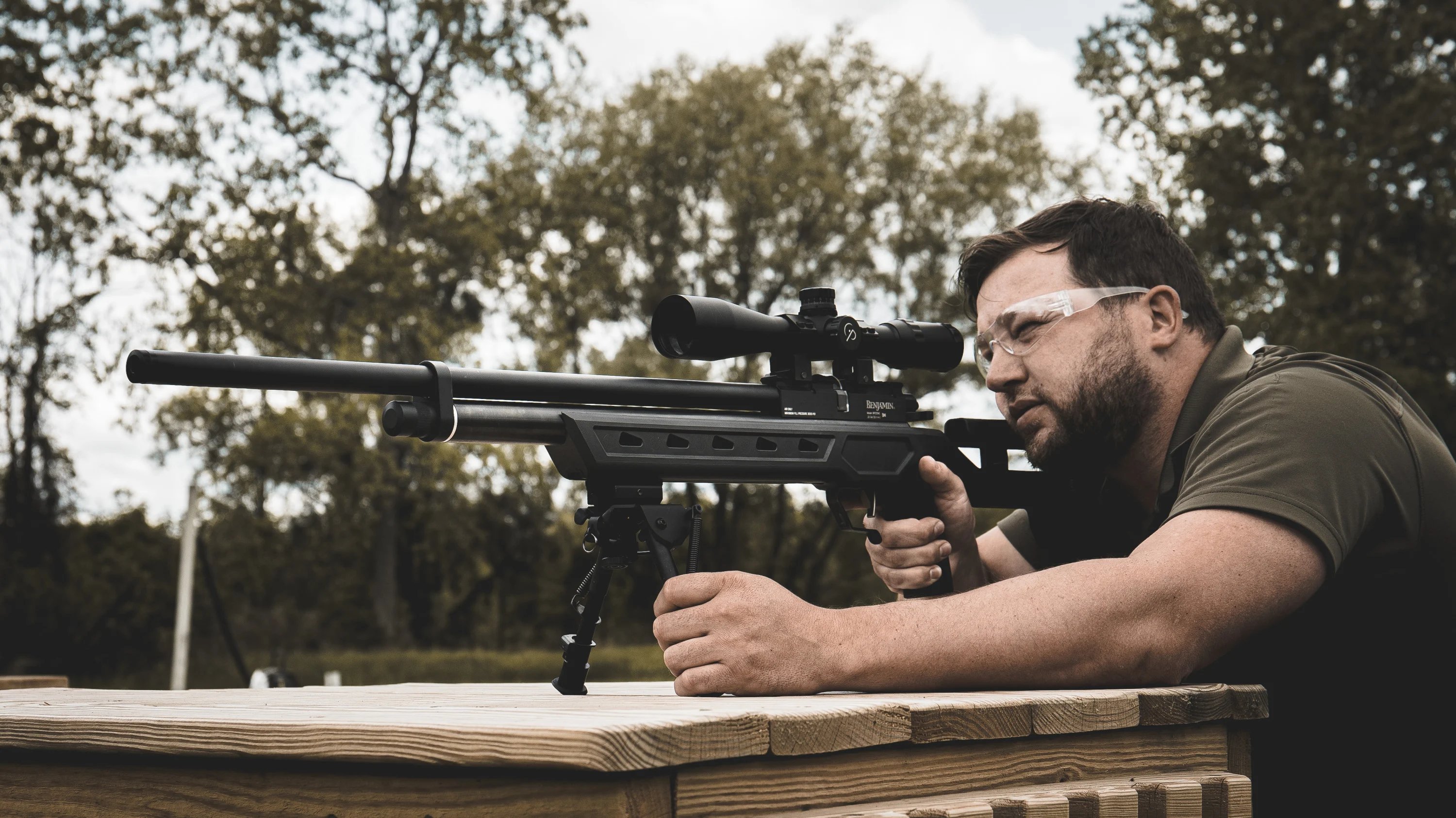 A man aiming through the scope on a Benjamin Armada Semi-Automatic tactical air rifle