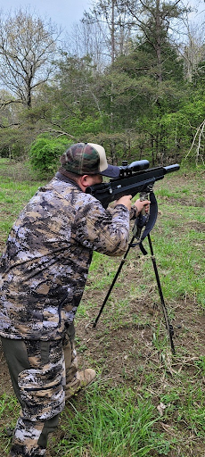 A man shooting with the Benjamin Bulldog M357 in a forest File name: Bulldog-M357-best-air-rifle-for-hog-hunting