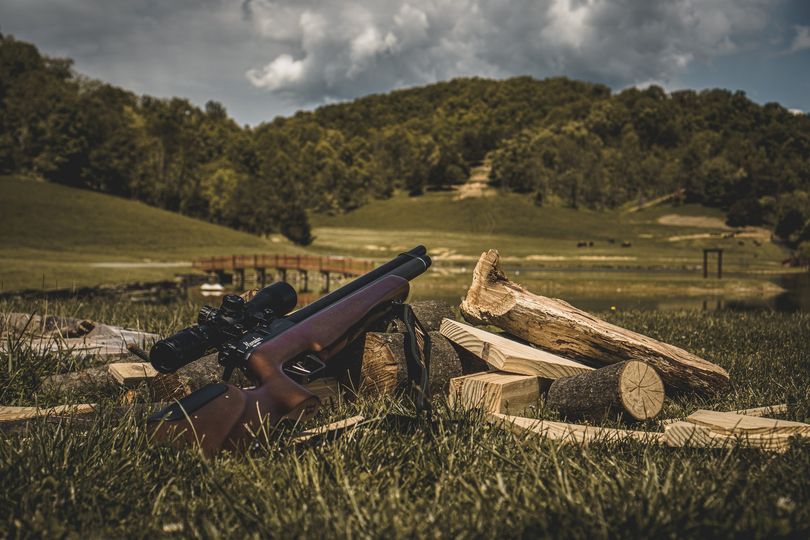 a Marauder air rifle laying on wood in the green outdoors
